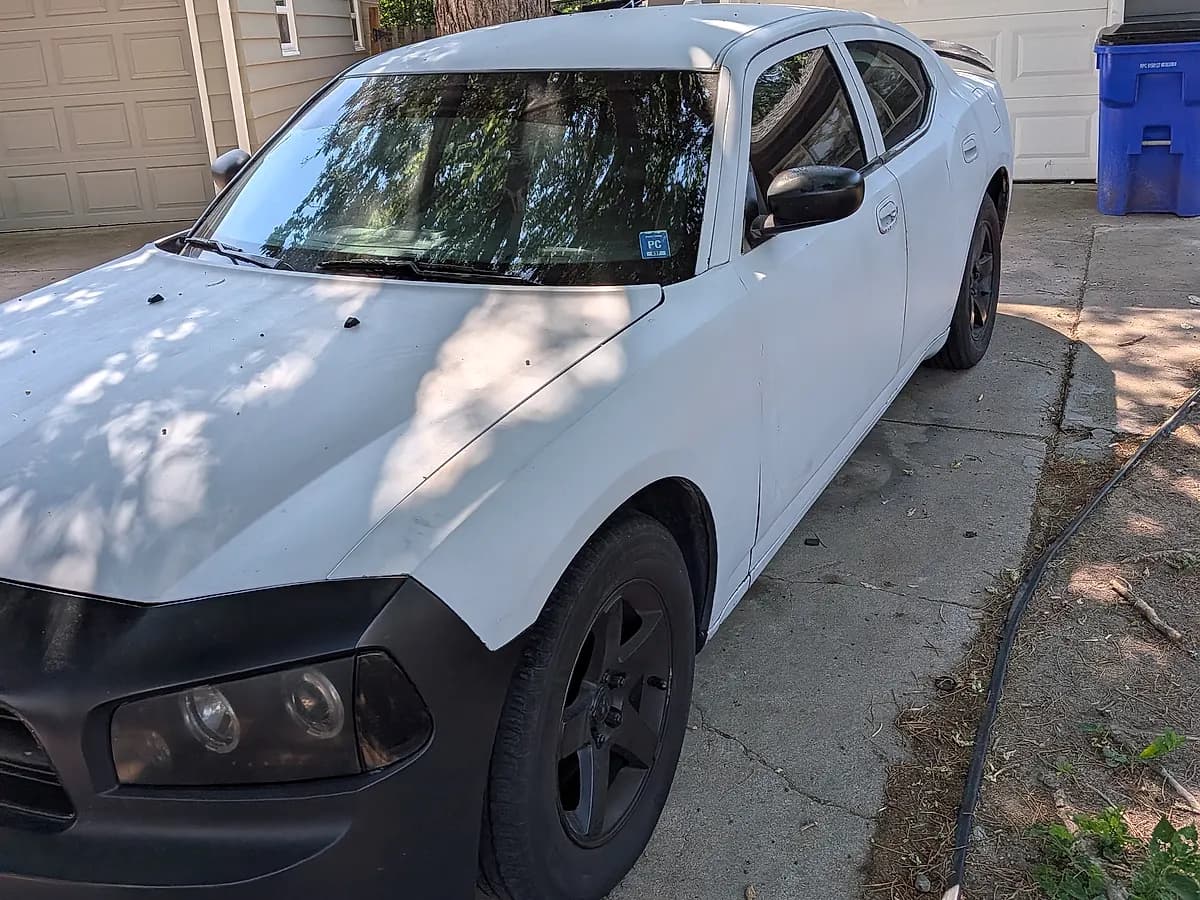 White 2008 Dodge Charger SXT with a black hood we bought for cash in a driveway