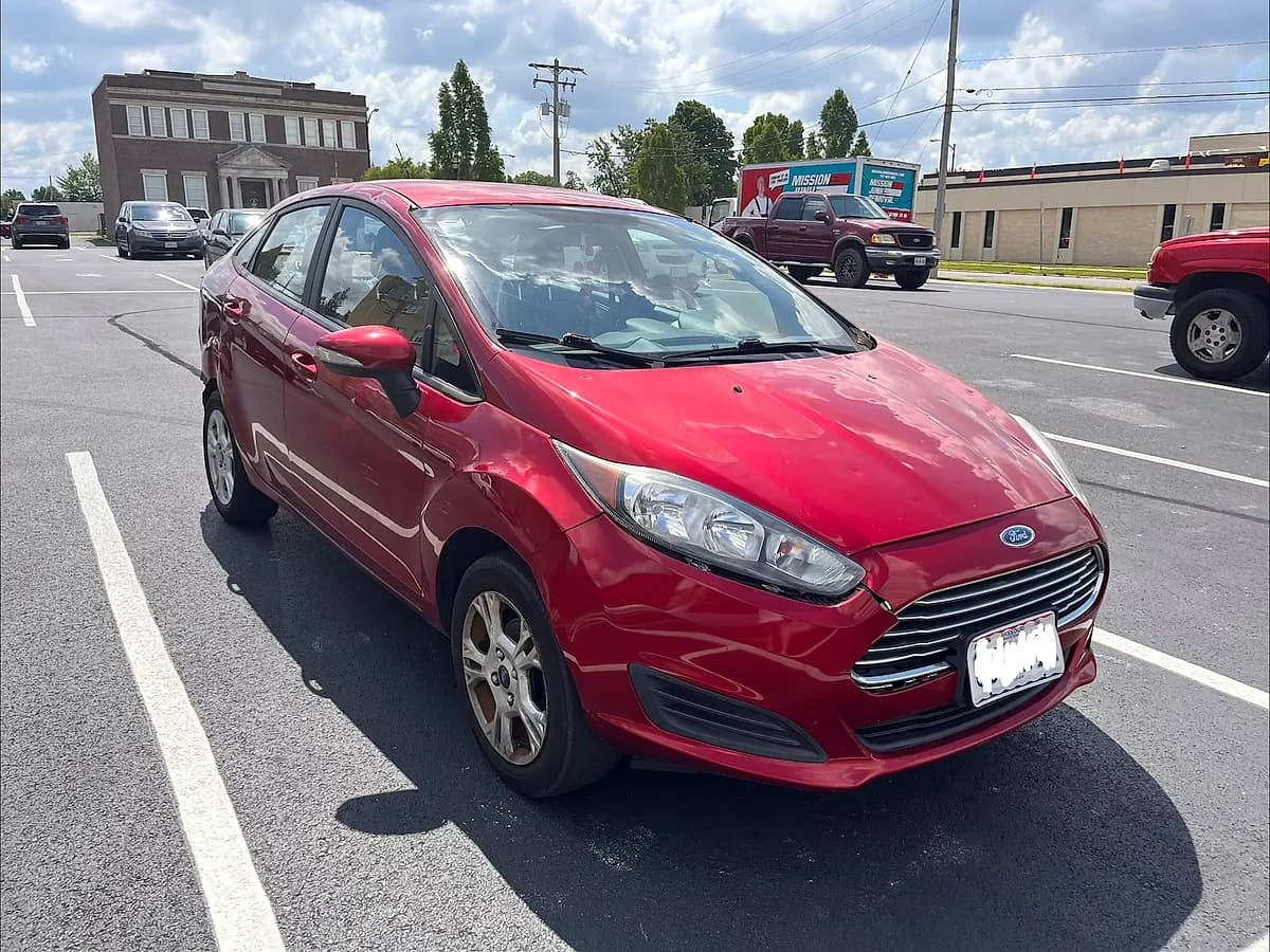 Red 2016 Ford Fiesta SE sedan we bought for cash in a parking lot