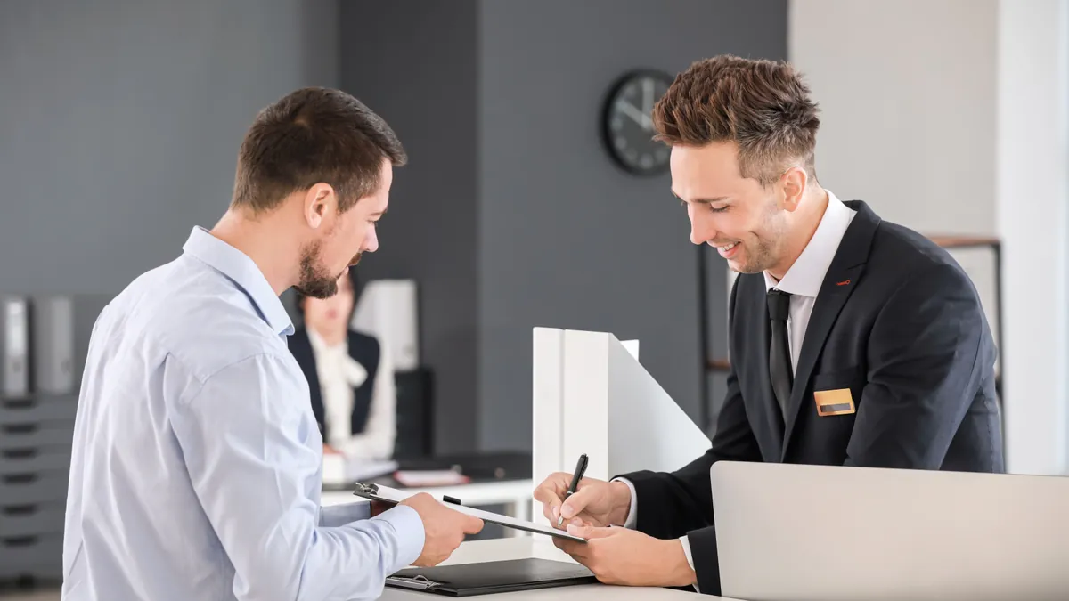 A DMV clerk helping a visitor at an office counter