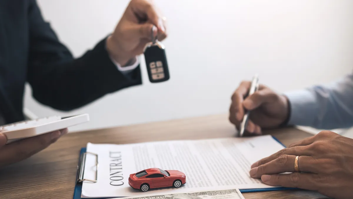 Signing finance contract documents at a dealership